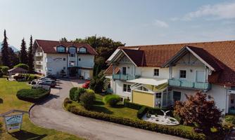 A quiet property with two buildings and a green garden. There are parking spaces and an inviting atmosphere.