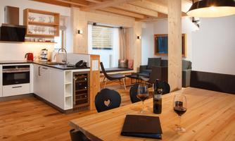 A modern apartment with wooden floors and clean lines. The open kitchen and dining area invite you to linger.