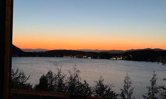 A beautiful viewpoint at Kloppeiner Lake during sunset. The colors of the sky are reflected in the water.