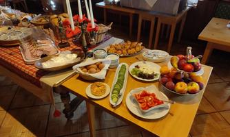 A rich buffet with various dishes, including cold cuts, fruits, and vegetables. The table is festively set and offers an inviting atmosphere.