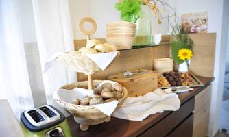 A table with various breads in baskets and a selection of cookies. The presentation is friendly and inviting.