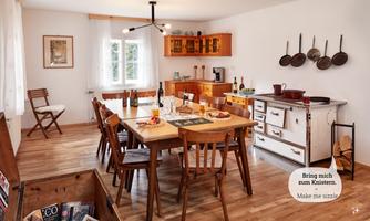 An inviting kitchen with a large dining table and wooden furniture. The room is bright and friendly, ideal for social gatherings.