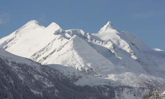Snow-covered mountains under a clear blue sky. The majestic landscape radiates tranquility and beauty.