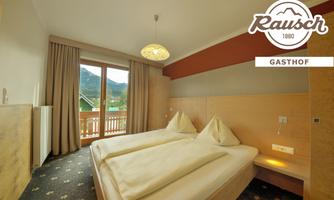 A cozy room with two beds and large windows. The room is bright and modern furnished with a view of the surrounding mountains.