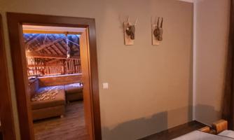 A cozy room with a view of an adjacent living room. The walls are subtle and decorated with two antlers.