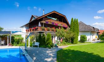 A beautiful house with a garden and a pool. The surroundings are green and sunny, ideal for relaxation.