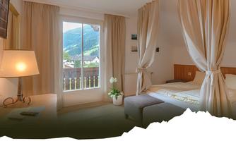 A cozy bedroom with a clear view of the mountains. The soft curtains and gentle light create a relaxed atmosphere.