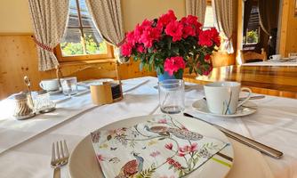 A beautifully set table with a bouquet and elegant table decoration. The soft lighting creates a cozy atmosphere.