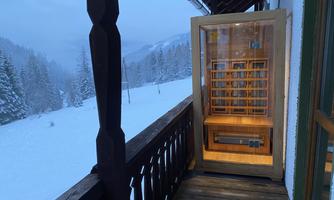 A small wooden library on a balcony, surrounded by snow-covered trees. In the background, there is a snow-covered landscape with mountains.
