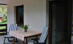 A cozy outdoor area with a table and two chairs. There is a beautiful view of nature.