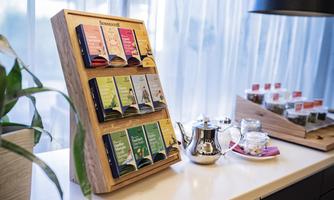 A stylish shelf with different types of tea and a teapot. In the background, some tea bags and a glass jar are visible.