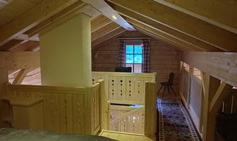 A cozy wooden attic with a bright window. The room is simply and invitingly designed.