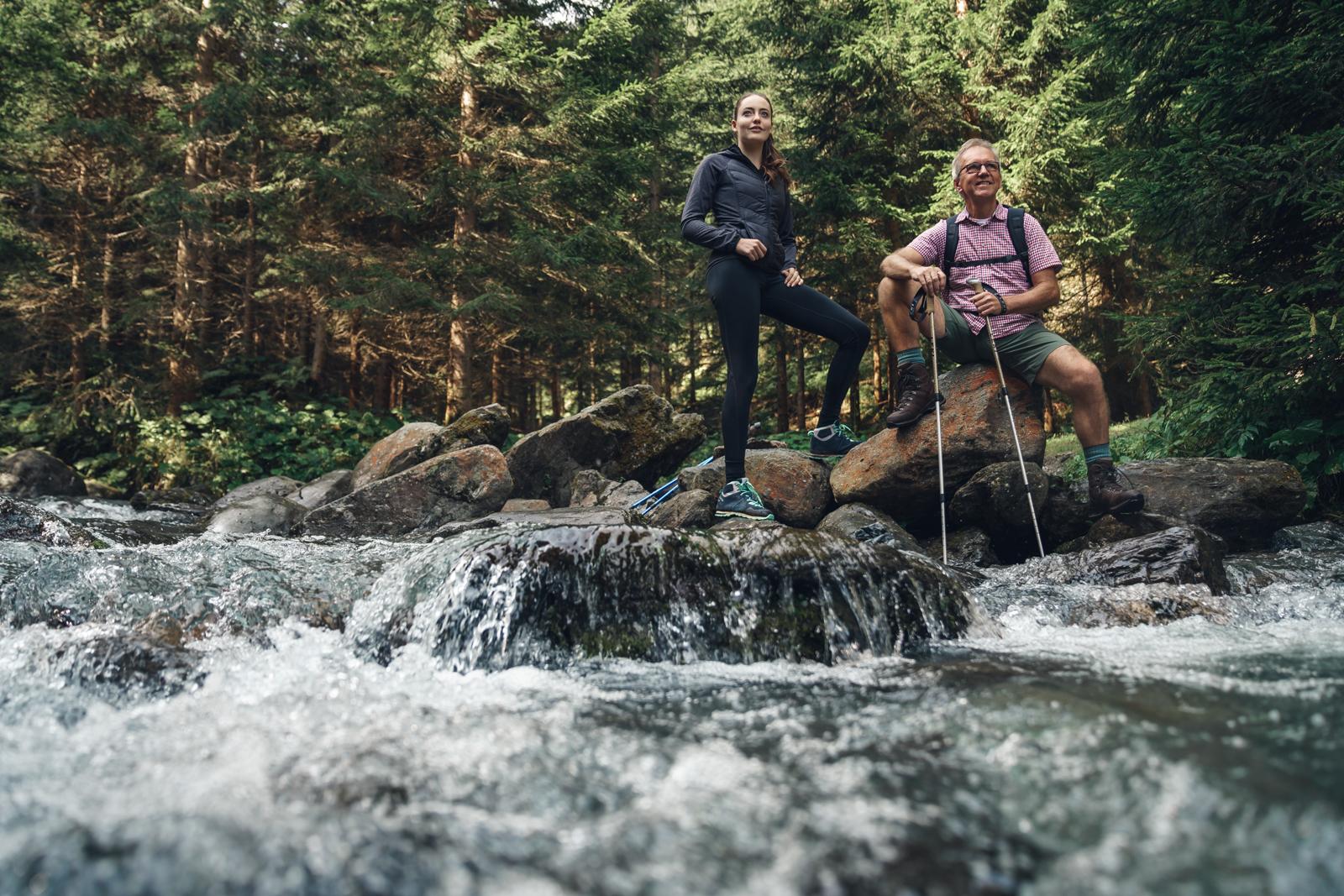 Wanderer in den österreichischen Alpen, Mann und Frau, pausieren an einem Gebirgsbach