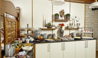 A rich breakfast buffet with various dishes and beverages. The tables are beautifully decorated and the room feels inviting.