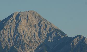 A majestic mountain with a rugged peak shape. The rocks are clearly visible and the landscape appears impressive.