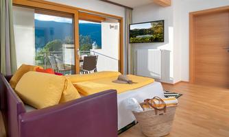 A modern room with large windows and a beautiful view of the mountains. The decor is in warm colors and invites relaxation.