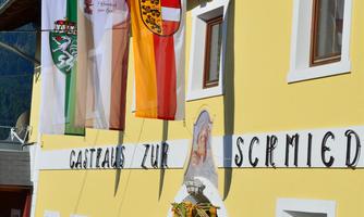 A yellow building with a sign and several flags. It is probably located in a rural or tourist area.