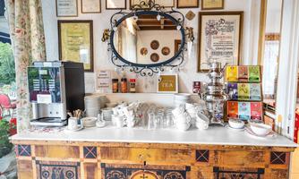 A cozy tea area with a wooden counter and various types of tea. Diplomas and a decorative mirror hang on the wall.