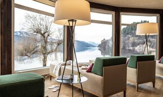 A cozy living space overlooking a tranquil lake. Large windows let in plenty of light and provide a beautiful view of nature.