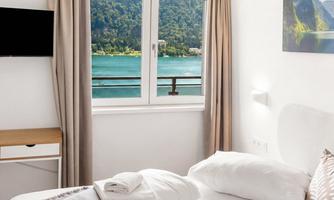 A bright room with a bedroom and a view of a lake. Large windows let in plenty of daylight and offer an attractive view of nature.