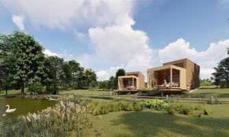Two modern wooden houses by the shore of a tranquil pond, surrounded by trees and greenery. A swan-like bird swims in the water under a clear sky.