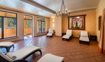 A quiet relaxation room with loungers and a view of large windows. An artistic picture hangs on the wall, creating a relaxing atmosphere.