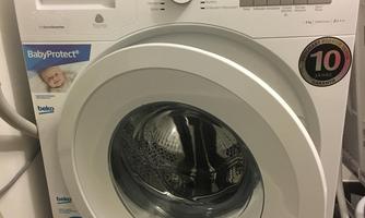 A modern washing machine in white with various settings. It features the "BabyProtect+" label and has a 10-year warranty.