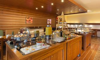 An inviting restaurant with a buffet area. The wooden shelves are filled with various foods and drinks.