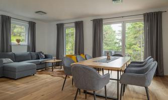 ‘A generously proportioned, open-plan living and dining area with elegant real wood parquet flooring invites you to linger. The stylish dining table comfortably seats up to eight people – ideal for convivial evenings with family and friends. Lovingly selected decorative elements lend the room a warm, homely atmosphere and create a harmonious feeling of being at home.’