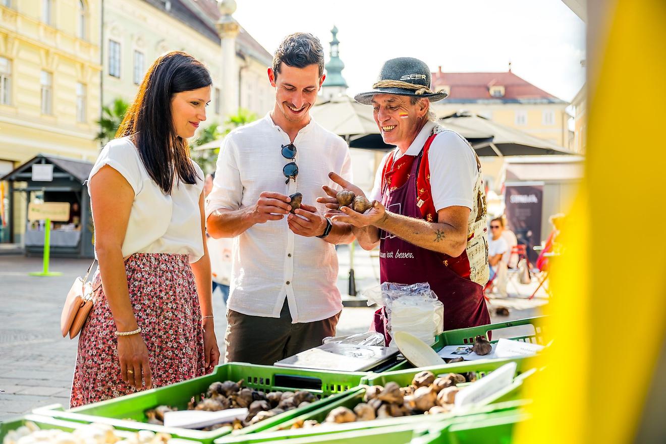 Trüffelverkäufer zeigt Kunden Trüffel auf einem Markt in Österreich