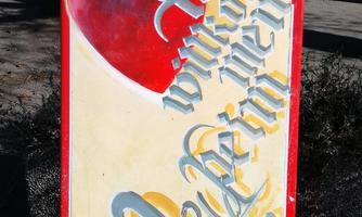 A colorfully designed sign with red hearts and artistic lettering. The text conveys a heartfelt message.