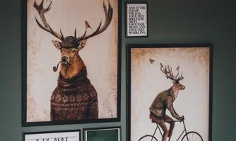 A creative wall with several picture frames. The motifs feature animal illustrations and inspiring quotes.
