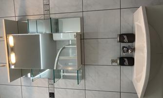 A modern bathroom with a sink and a mirror above the faucet. There are two soap dispensers on the sink.
