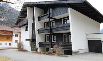 A modern building with black and white facades. It has several balconies and is located in a quiet environment.