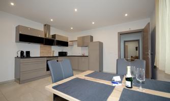 Modern kitchen with stylish furniture and an elegant dining group. The room is bright and inviting, ideal for shared meals.