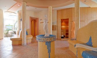 A cozy wellness area with a central statue. The walls are painted in warm colors and the ambiance conveys relaxation and tranquility.