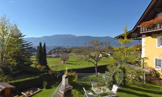 A picturesque view of the mountains with a well-maintained garden and a terrace. The landscape is green and inviting, perfect for relaxing days outdoors.