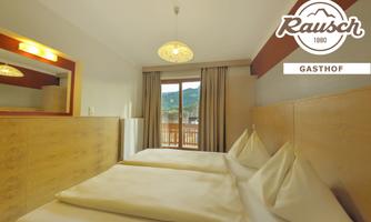 A bright room with two single beds and a large window. The view shows mountains and there is a cozy atmosphere.