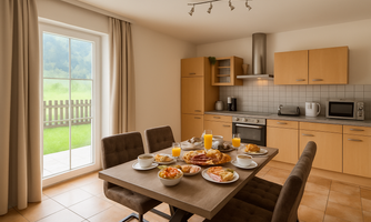 A modern kitchen with a dining area. The table is lavishly set with various foods and drinks, while in the background, a window opens up a view of greenery.