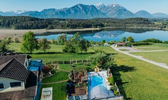 A picturesque landscape with a floating pool and a tranquil lake. Majestic mountains rise in the background under a clear sky.