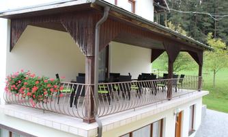 A cozy balcony with seating and blooming flowers. The surrounding nature creates a peaceful atmosphere.