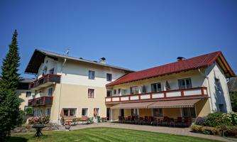 A charming building with two floors and a red roof. The garden is well-kept and invites relaxation.