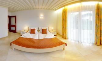 A modern bedroom with a large double bed and elegant decor. Large windows provide plenty of daylight and create an inviting atmosphere.