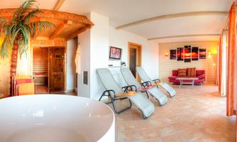 A relaxing wellness area with loungers and a sauna. The warm colors create an inviting atmosphere.