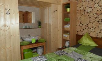 A cozy room with wooden details and a modern bathroom. The decoration in various shades of green creates a relaxed atmosphere.