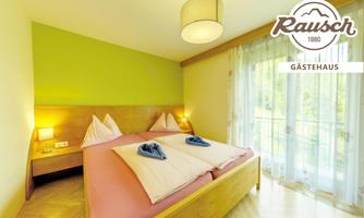 A cozy bedroom with a large double bed and fresh colors. The large windows let in plenty of light and provide access to a balcony.