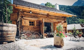 A charming wooden house in the midst of nature. Surrounded by flowers and rustic accessories, it radiates coziness.
