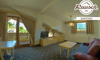 An inviting room with a television and a table. Large windows offer a view of the surrounding landscape.