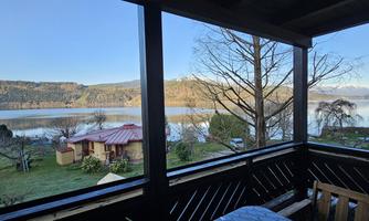 A beautiful view of a tranquil lake, surrounded by mountains and trees. The atmosphere is peaceful and inviting.