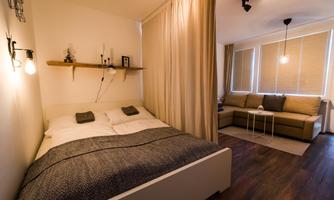 A modern room with a double bed and a cozy seating area. The warm colors and wooden details create an inviting atmosphere.